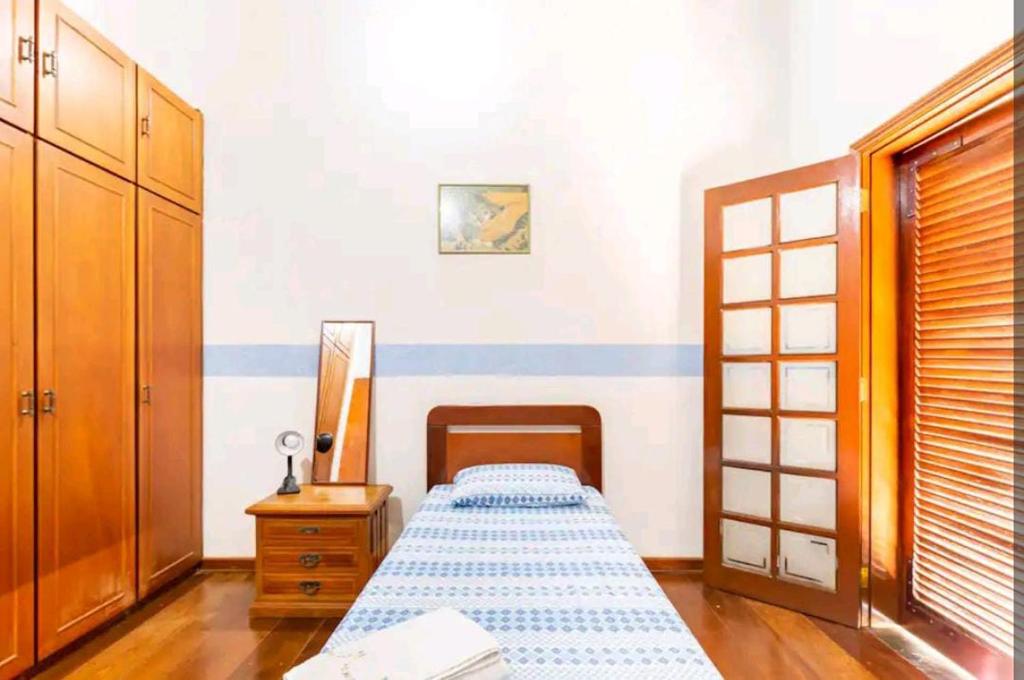 a bedroom with a bed and a dresser and a mirror at Casa na Granja Viana - Cotia in Cotia