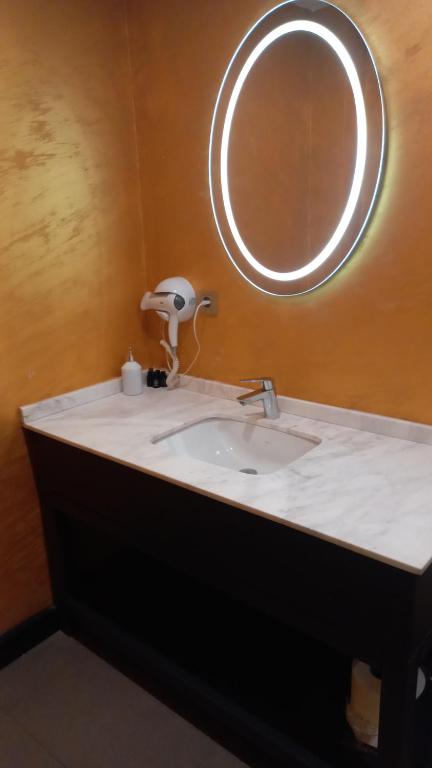 Acar Suite Hotel في إسطنبول: منضدة الحمام مع الحوض والمرآة