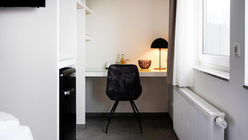 a black chair sitting at a desk in a room at SI-View Doppelzimmer mit Stadtblick Zimmer 20 in Siegen