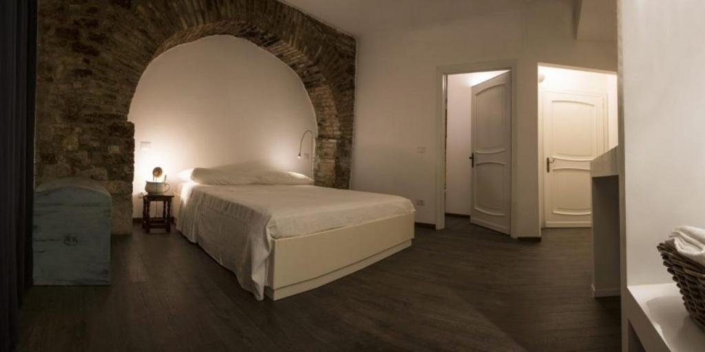 アッシジにあるResidenza La Corte Assisiのレンガの壁、ベッド付きのベッドルーム1室