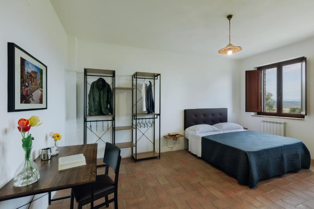 1 dormitorio con cama, mesa y escritorio en Il Vecchio Braciere, en Civitella deʼ Conti