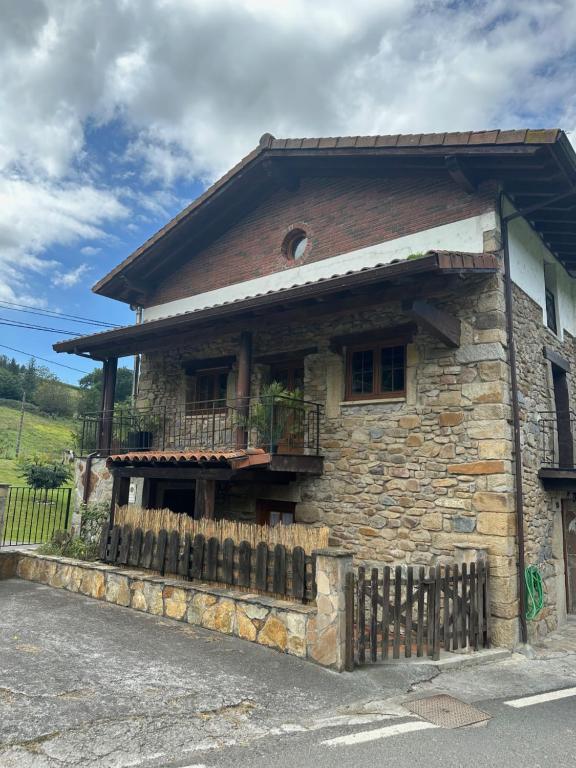 uma casa de pedra com uma cerca em frente em K13 em Concha