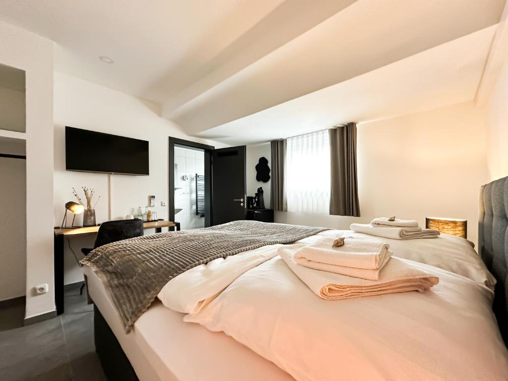 a bedroom with a bed with two towels on it at Si-View Doppelzimmer Zimmer 10 in Siegen