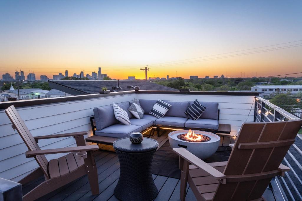 een balkon met een bank en stoelen en een vuurplaats bij Upstay - City Views & Stargazing on Rooftop Patio in Austin