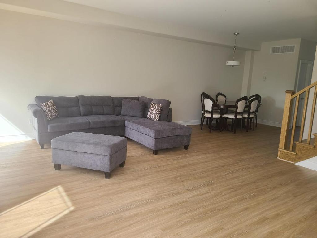 een woonkamer met een bank en een tafel en stoelen bij Ensuite Bedroom –Double Bed: Mins from Coburg Beach in Cobourg