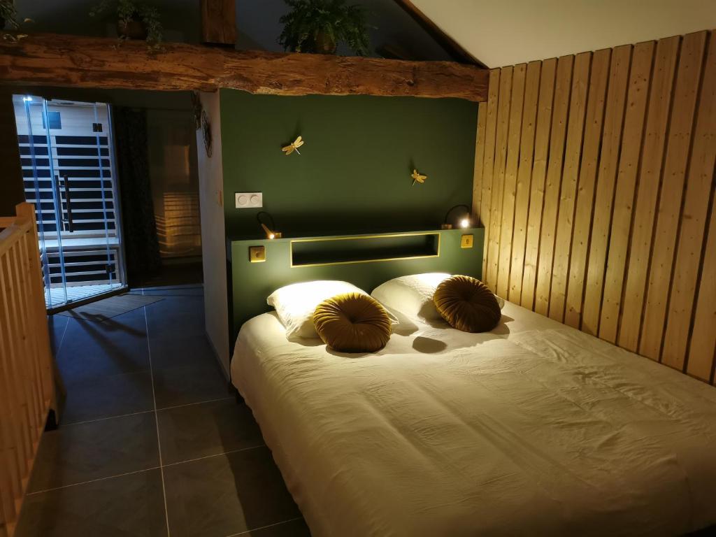 1 dormitorio con 1 cama con pared verde en Gite La Maisonnette, en Chancelade
