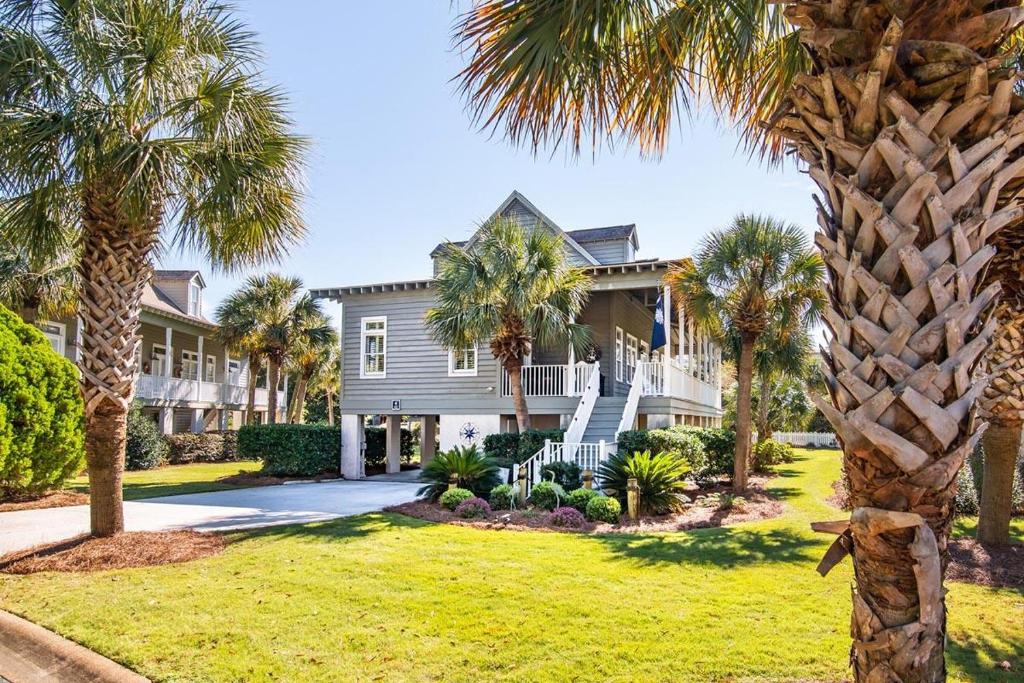 a house with palm trees in front of it at A 4 Bedroom House in Gated Litchfield By the Sea in Pawleys Island