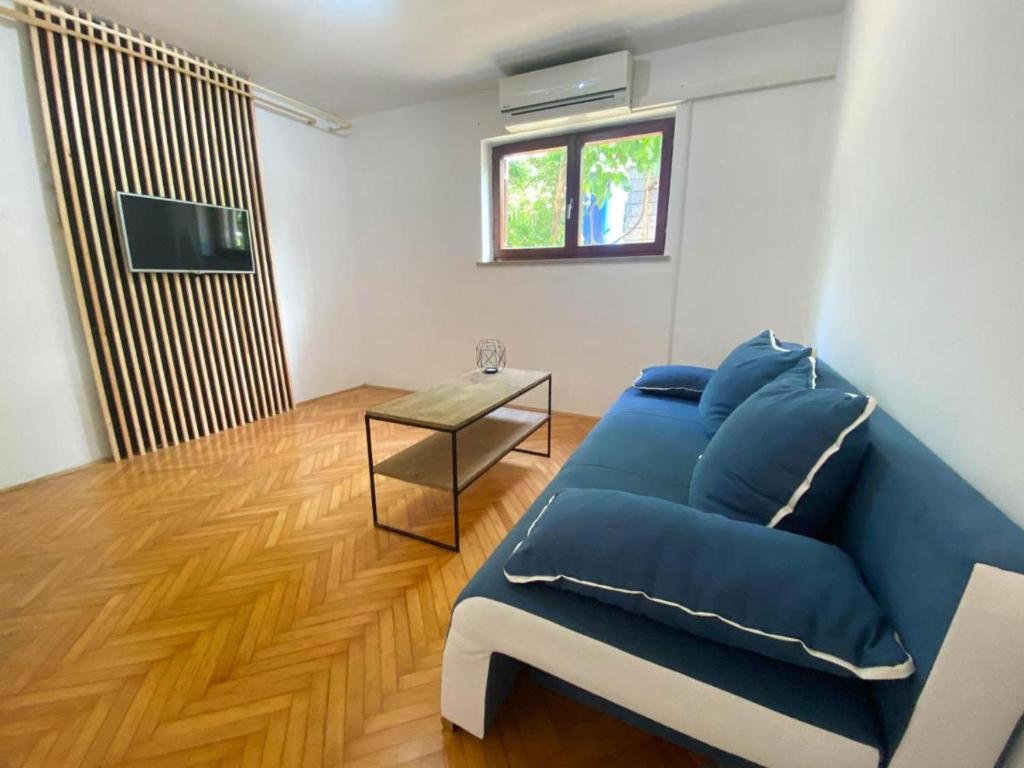 a living room with a blue couch and a table at Cute & Cosy Apartment Emi in Koper
