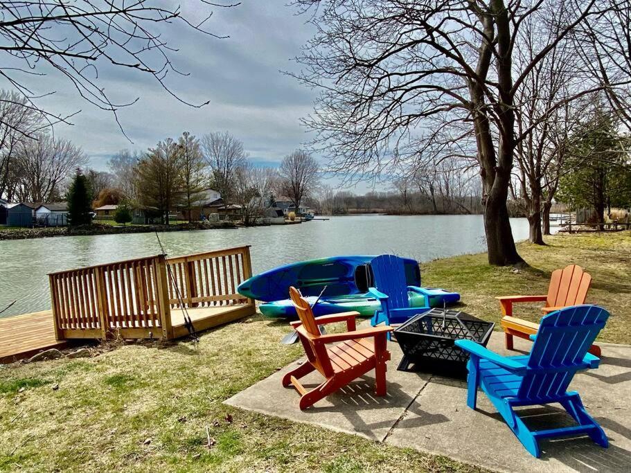 a group of chairs and a table next to a lake at Creekside Cottage - kayak/SUP, fishing, game room in Kingsville