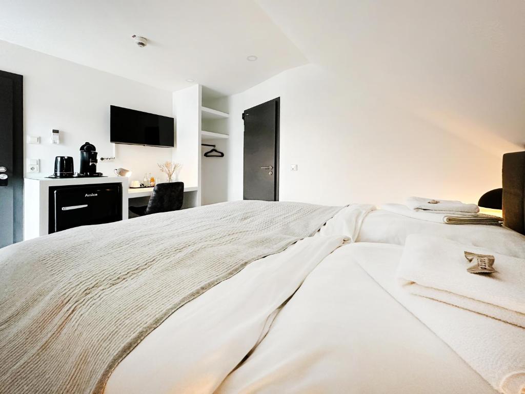 a white bedroom with a large white bed at SI-View Doppelzimmer Zimmer 23 in Siegen