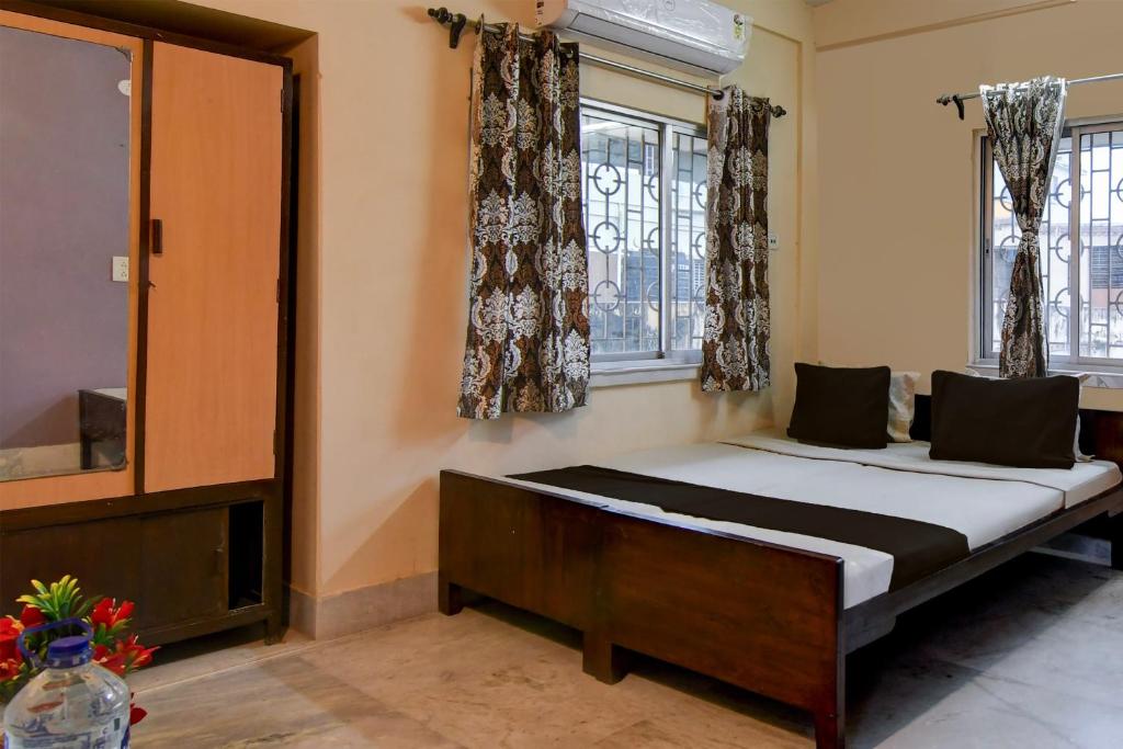 een slaapkamer met een bed en 2 ramen bij OYO Florence Guest House And Home Stay in Calcutta