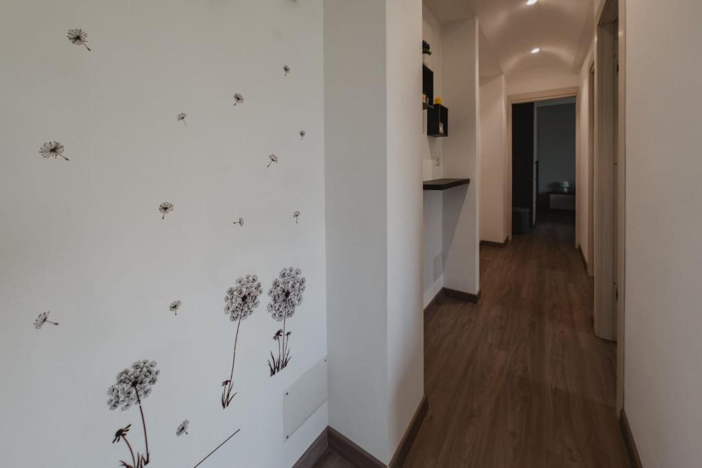 un corridoio con un muro bianco con dei fiori di Guest House Cefalù a Cefalù