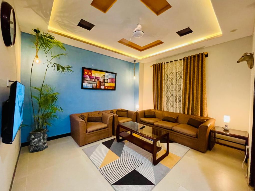 a living room with a couch and a table at Own It Apartment Brown in Islamabad