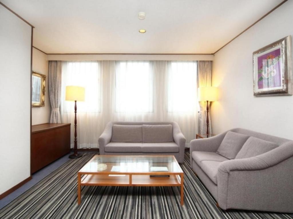 Sala de estar con 2 sofás y mesa de centro en Suikoyen Hotel - Vacation STAY 46481v, en Kurume