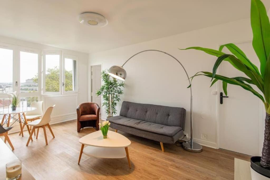 a living room with a couch and a table at Appartement spacieux aux portes de Paris in Châtillon