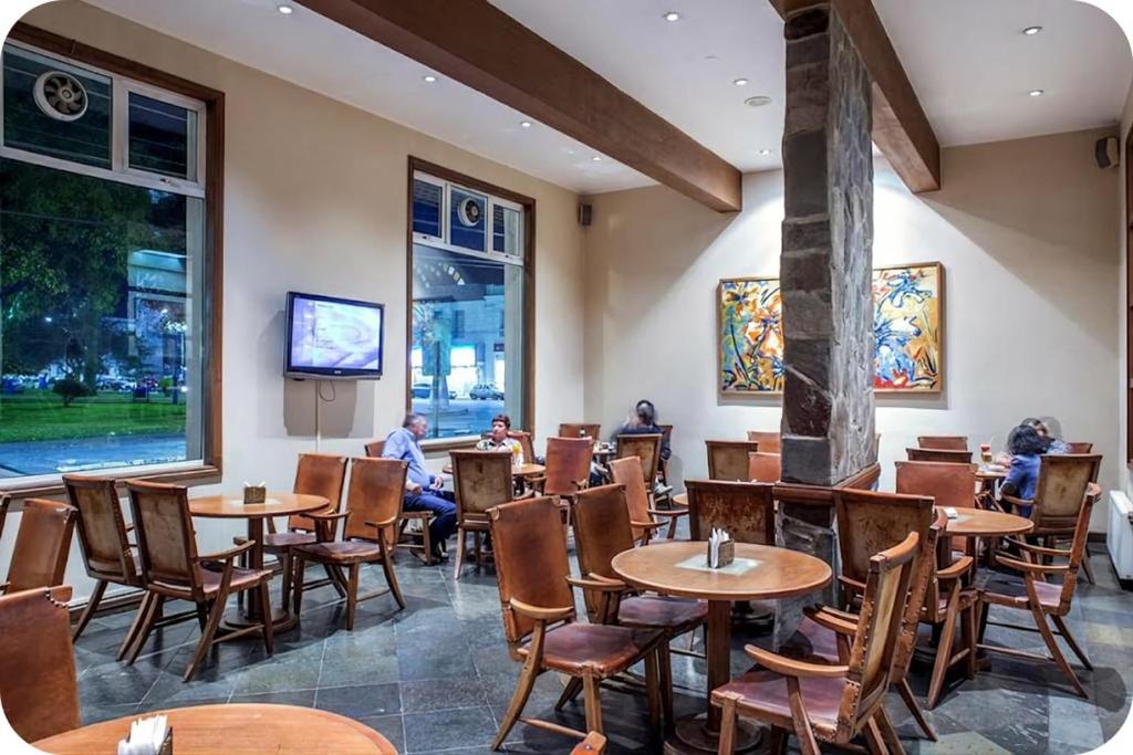 un restaurante con mesas y sillas y personas sentadas en mesas en Gran Hotel Isabel Riquelme, en Chillán