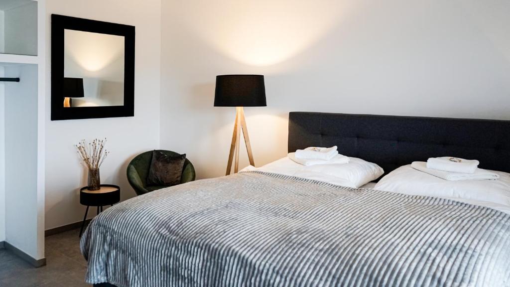 a bedroom with a bed and a lamp and a mirror at Si-View Doppelzimmer mit Balkon Zimmer 8 in Siegen