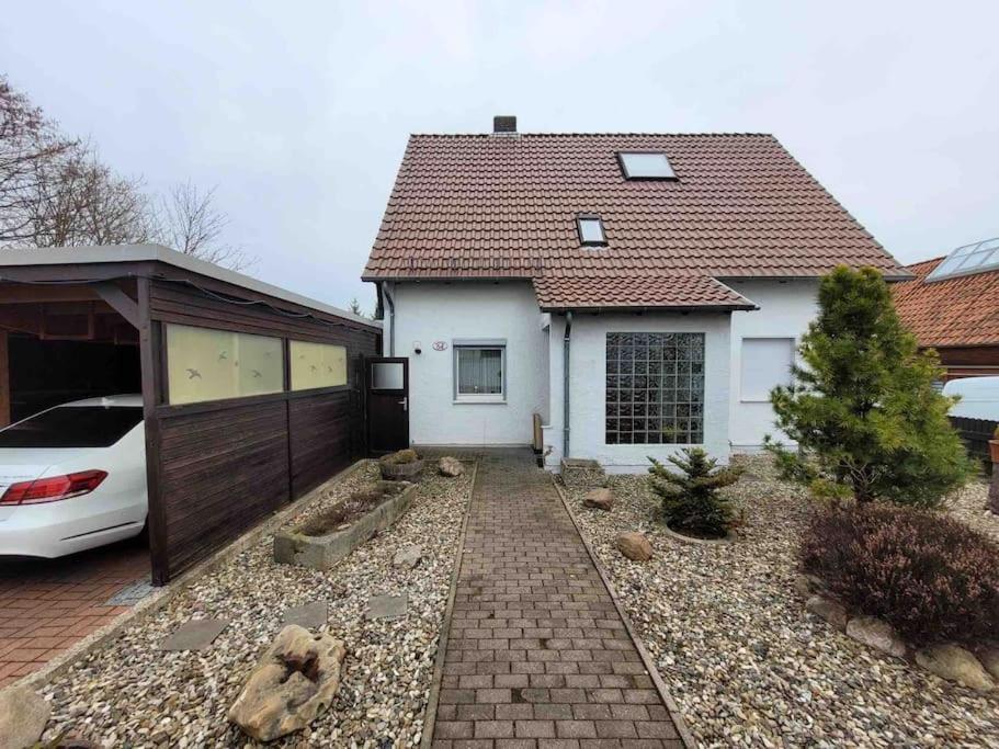 uma casa branca com um carro estacionado em frente dela em House in Sarstedt! contactless check-in 20P em Sarstedt