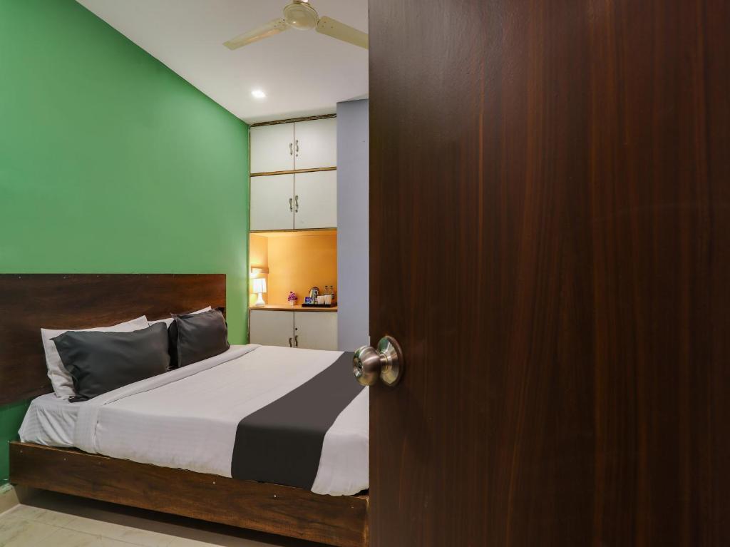 a bedroom with a bed and a wooden door at OYO Hotel Ragas in Hyderabad