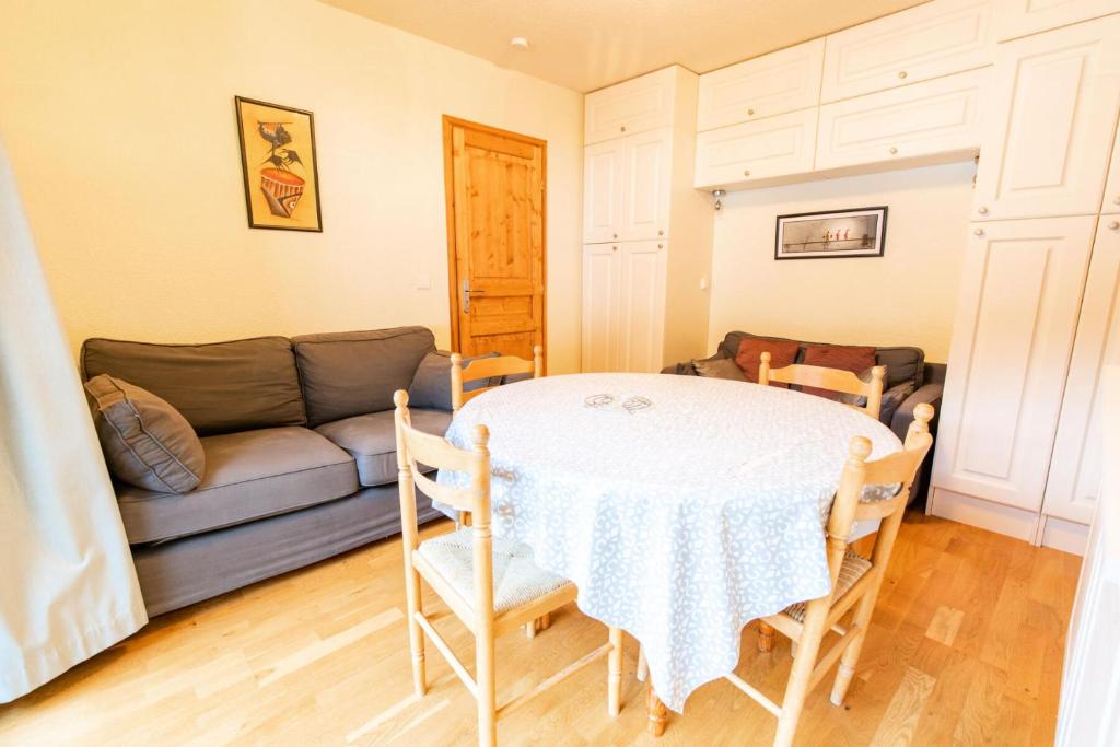 a living room with a table and a couch at Résidence Les Portes De La Vanoise - 2 Pièces pour 6 Personnes in Villarodin-Bourget
