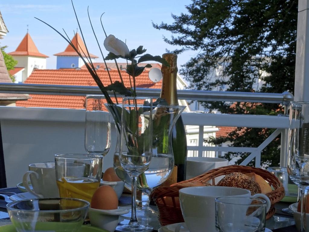 a table with a vase of flowers and glasses at Zinnowitz, Fewo Sonnendomizil in Zinnowitz