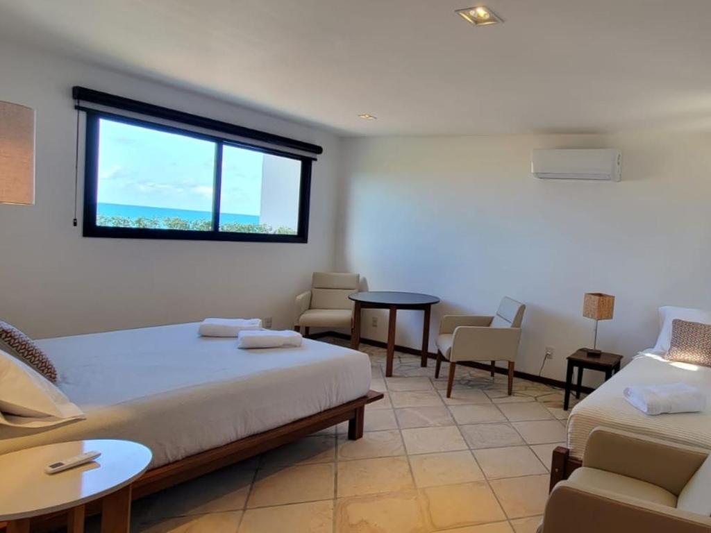 um quarto com duas camas e uma mesa e cadeiras em Arandu Sagi Inn em Baía Formosa