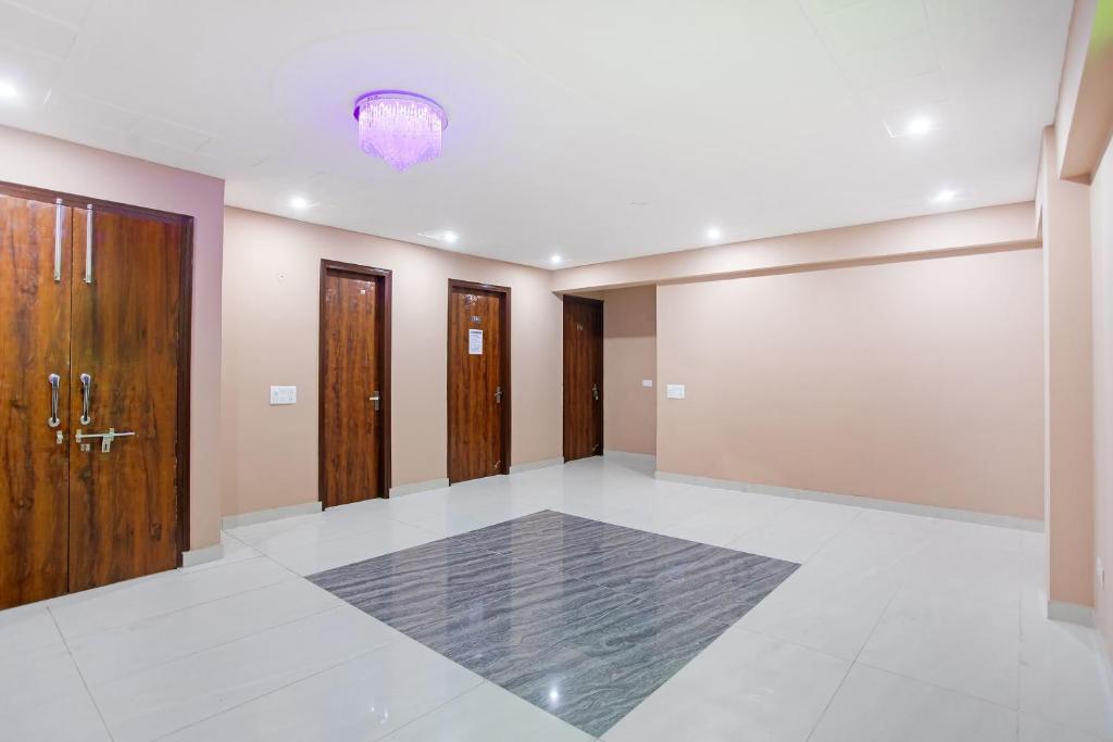 Habitación grande con puertas de madera y pared. en Super Capital O 62990 Harish Residency, en Gurgaon
