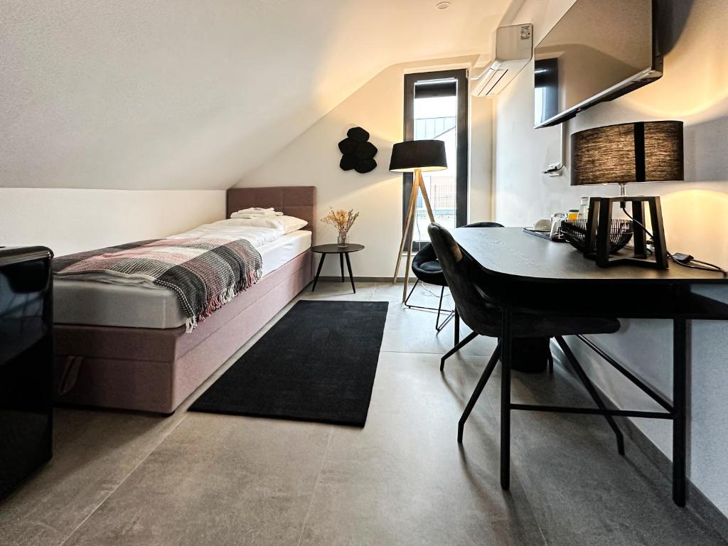 1 dormitorio con cama y escritorio. en SI-View Einzelzimmer Zimmer 9 en Siegen