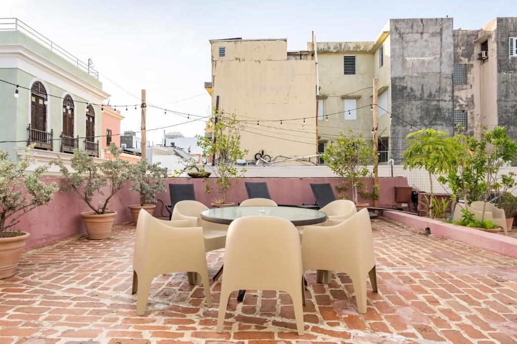 um pátio com uma mesa, cadeiras e edifícios em Center of Old San Juan with Rooftop Garden em San Juan