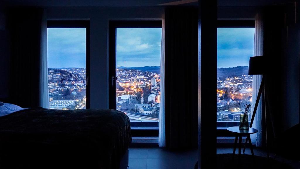 a bedroom with a view of a city through windows at SI-View Doppelzimmer mit Stadtblick Zimmer 17 in Siegen