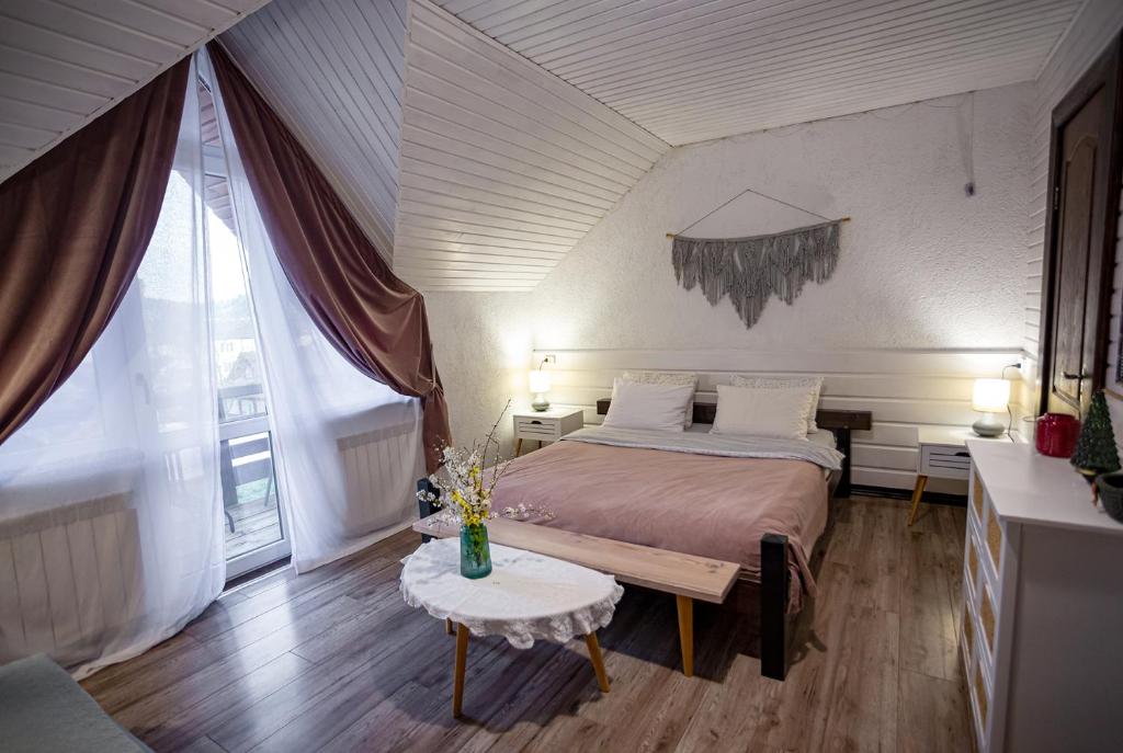 a bedroom with a large bed and a table at Захарова Оселя in Slavske