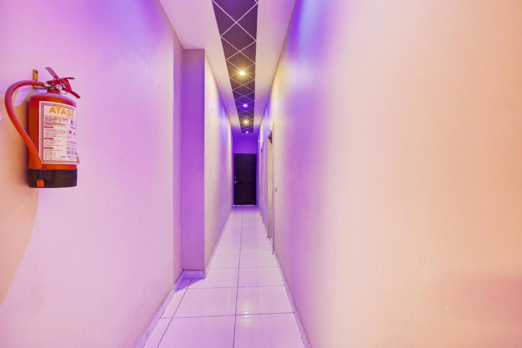 Kurukshetra的住宿－OYO Hotel Sarovar，一条带紫色墙壁和长走廊的走廊