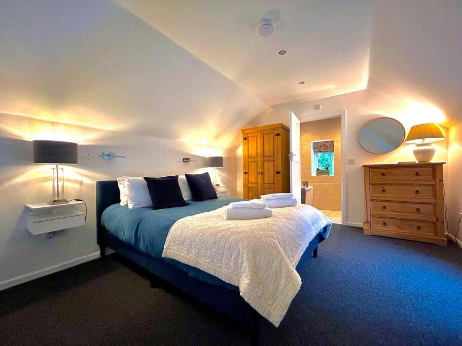 um quarto com uma cama grande e uma cómoda em The Barn em Cam