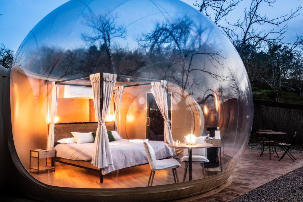a bedroom in a glass dome with a bed and a table at Horizonte Bubble rooms in Cortegana