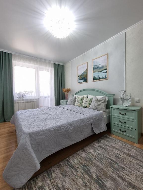 a bedroom with a large bed and a chandelier at Идеальная 4-х комн, с домашним уютом и простором in Kostanay