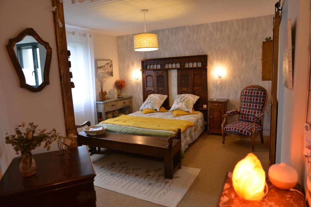 1 dormitorio con cama, mesa y espejo en Villa Cap Avalenn, en Fouesnant