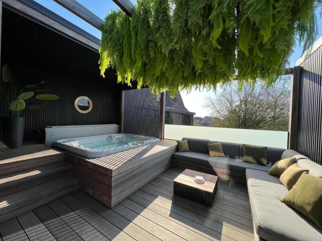 a patio with a jacuzzi tub on a deck at SUBSTANTIEL - Luxury Rooms & Wellness Suite in Brunehaut