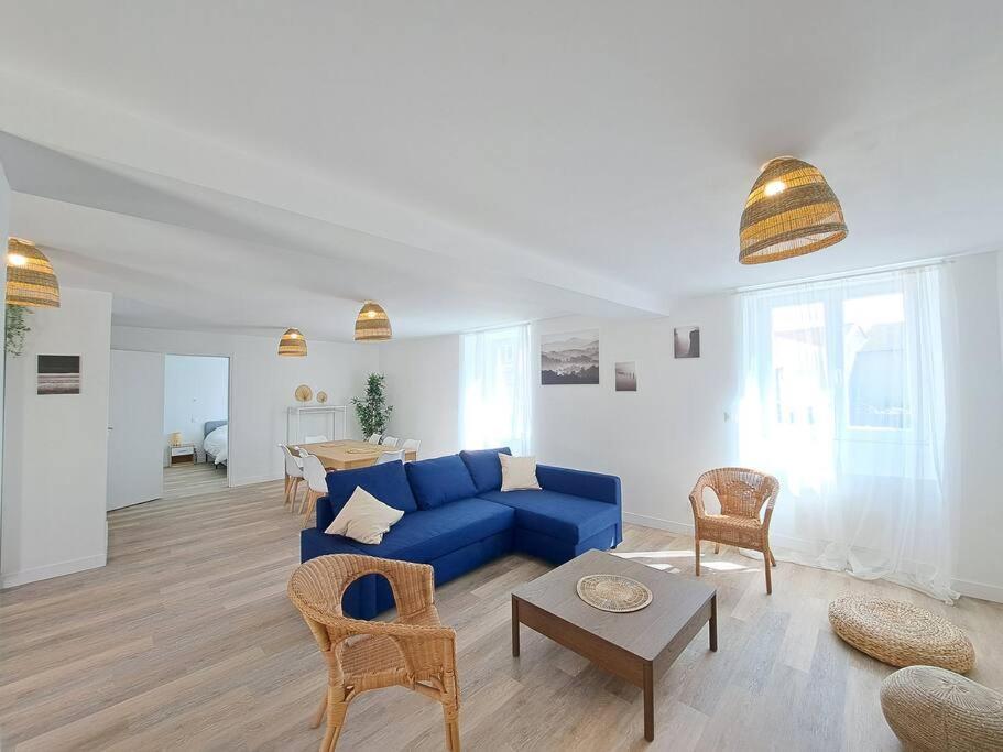 a living room with a blue couch and chairs at Moscow, Maison spacieuse proche Reims in Berru