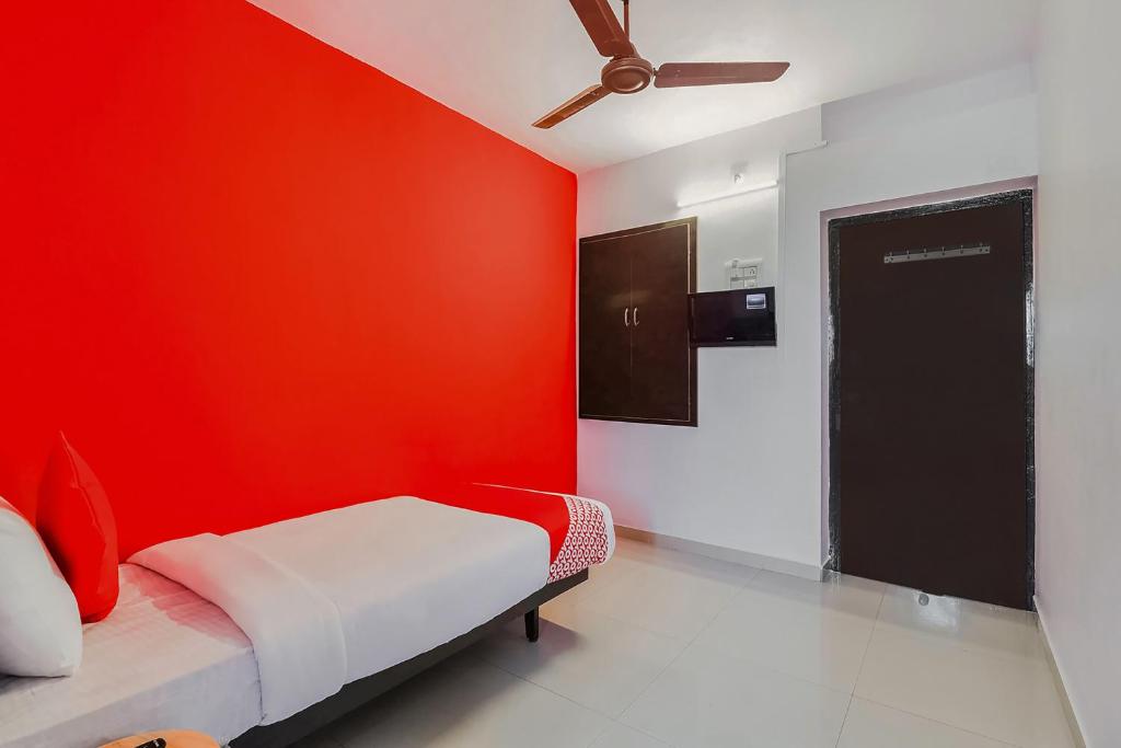 a red room with a bed with a red wall at Flagship Hotel Maruthi Gandhi Park in Coimbatore