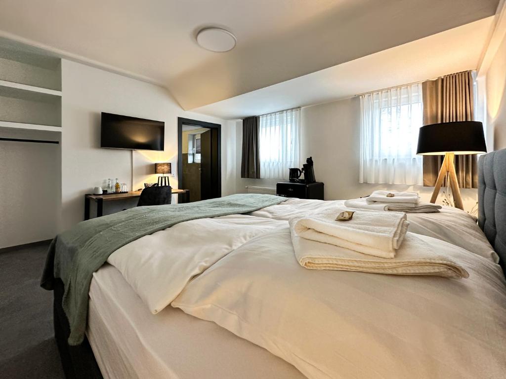 a bedroom with a large bed with towels on it at Si-View Doppelzimmer Zimmer 14 in Siegen