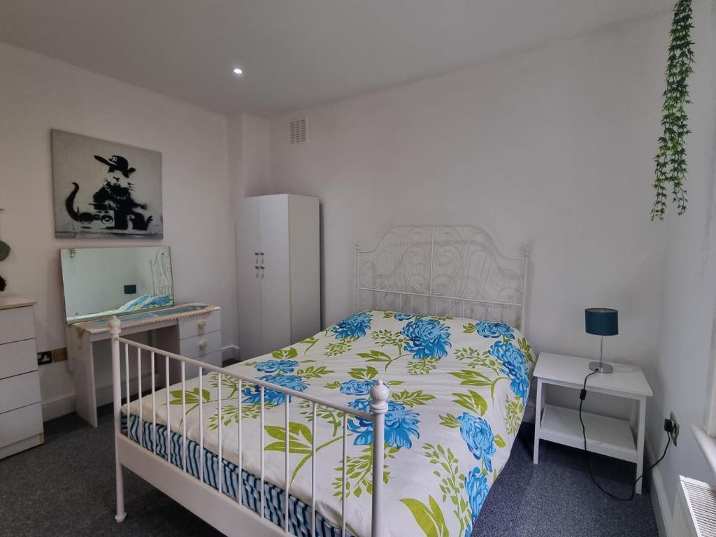 Un dormitorio con una cama con flores azules. en London Zone 2, Easy Travel, en Londres