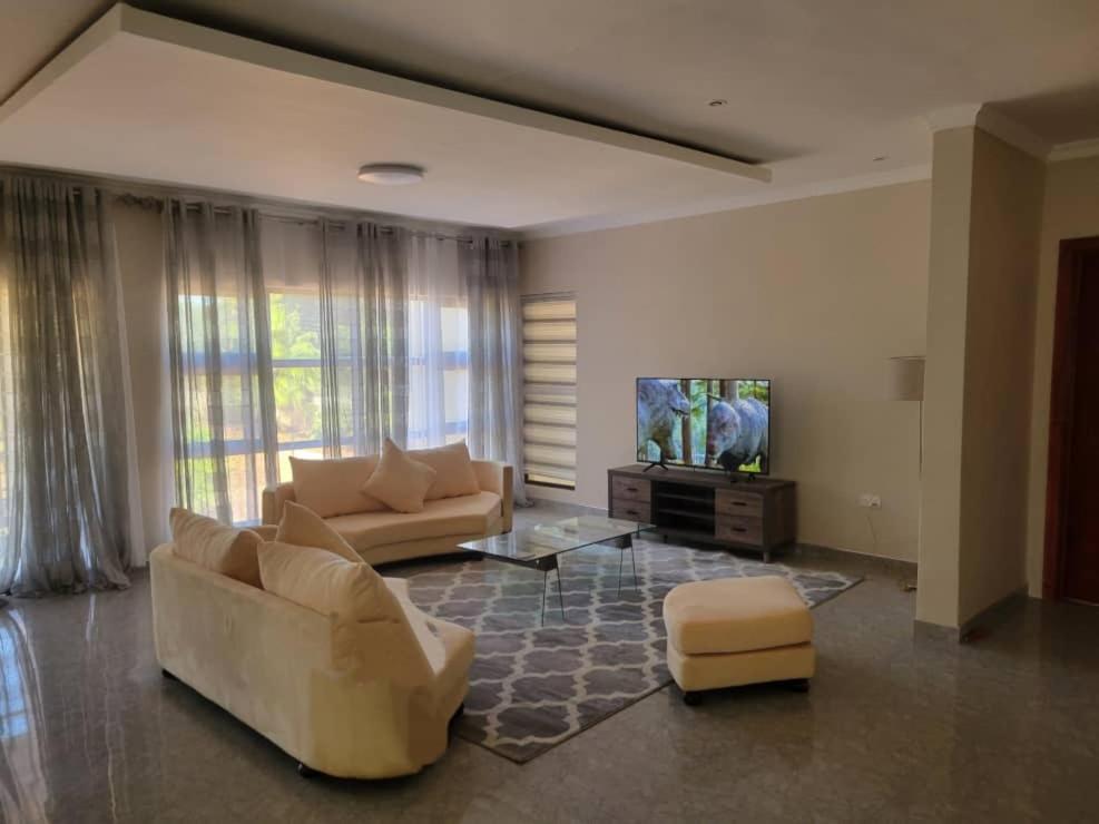 a living room with two couches and a flat screen tv at Sable Suites B1, 1 Bed Apartments in Kabulonga in Lusaka