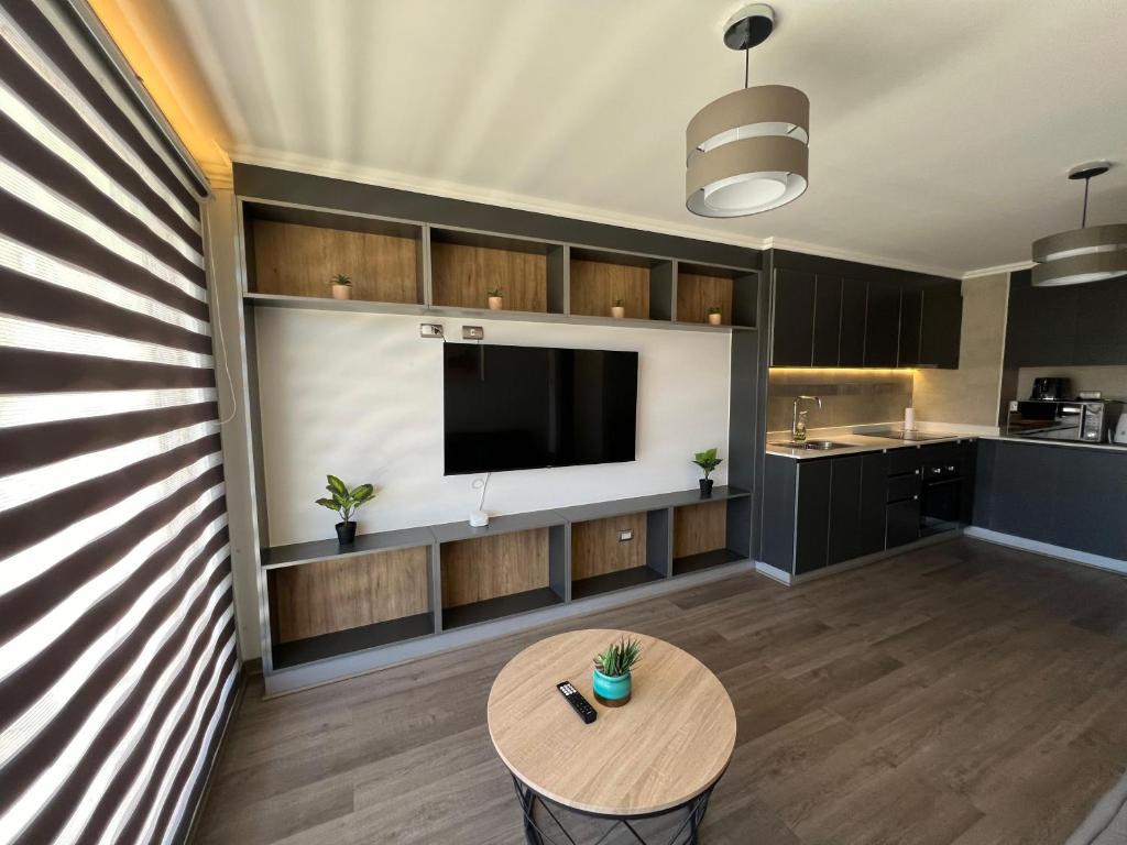 a living room with a table and a tv at Departamento 2D 2B in Los Ángeles
