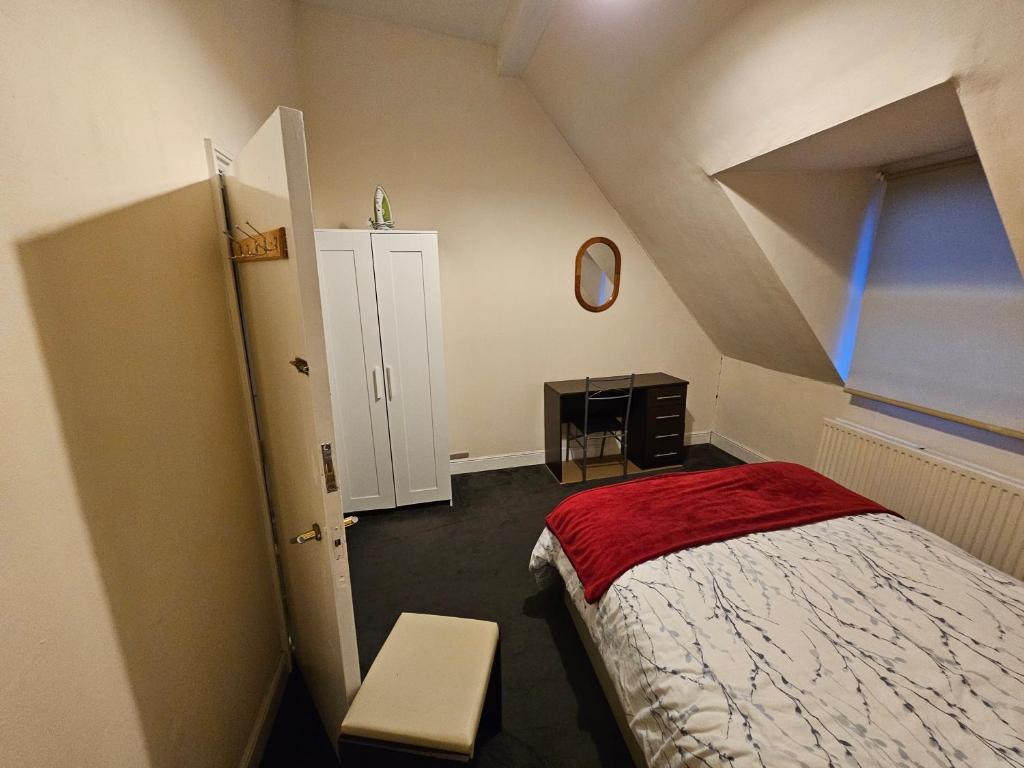 a attic room with a bed and a window at Harlesden, London in London