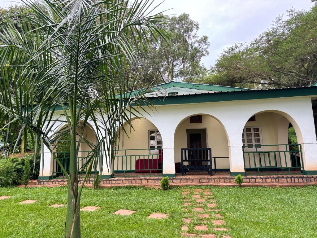 ein Haus mit einer Palme im Hof in der Unterkunft Muhazi View Resort in Muhazi