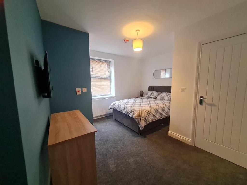 a bedroom with a bed and a window and a door at Cozy 6 Bedroom HMO in Eston