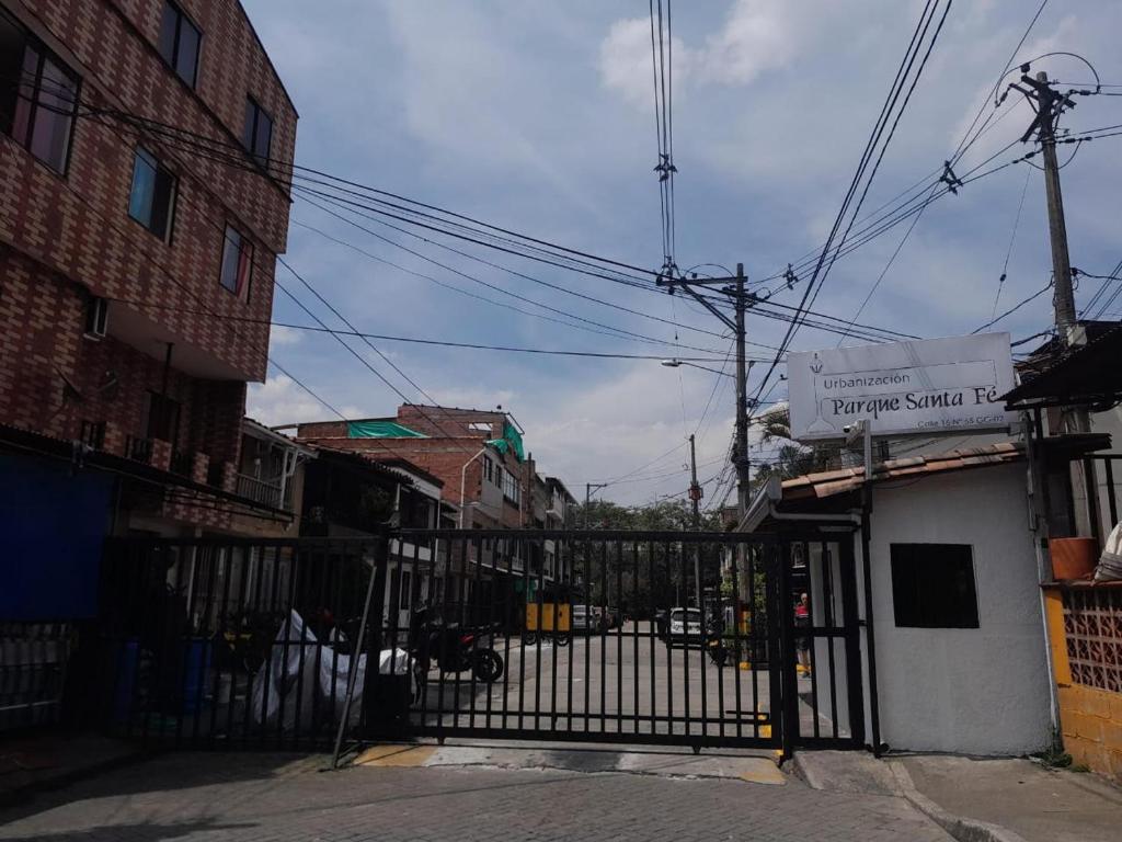 a gate in a street with a building and buildings at El Noral in Medellín