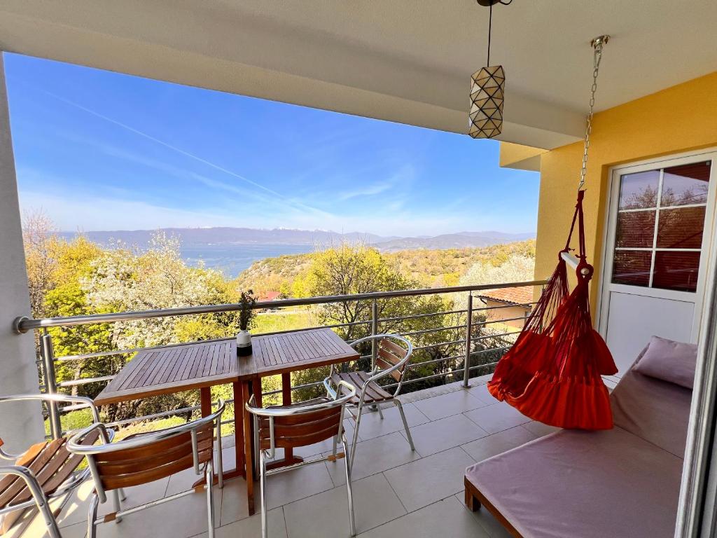 a balcony with a hammock and a table and chairs at Villa Velestovo in Ohrid