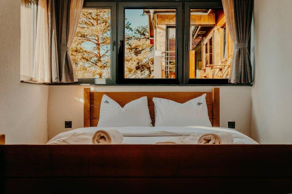 una camera da letto con un letto con due cuscini e una finestra di Chiplakova cottage by MRS a Berovo