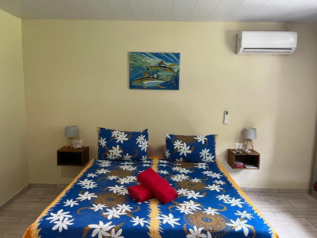 a bedroom with a blue bed with two red pillows at Tuna House in Maroe